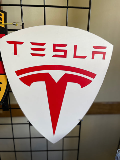 A replica Tesla logo with the background white and red T and red Tesla